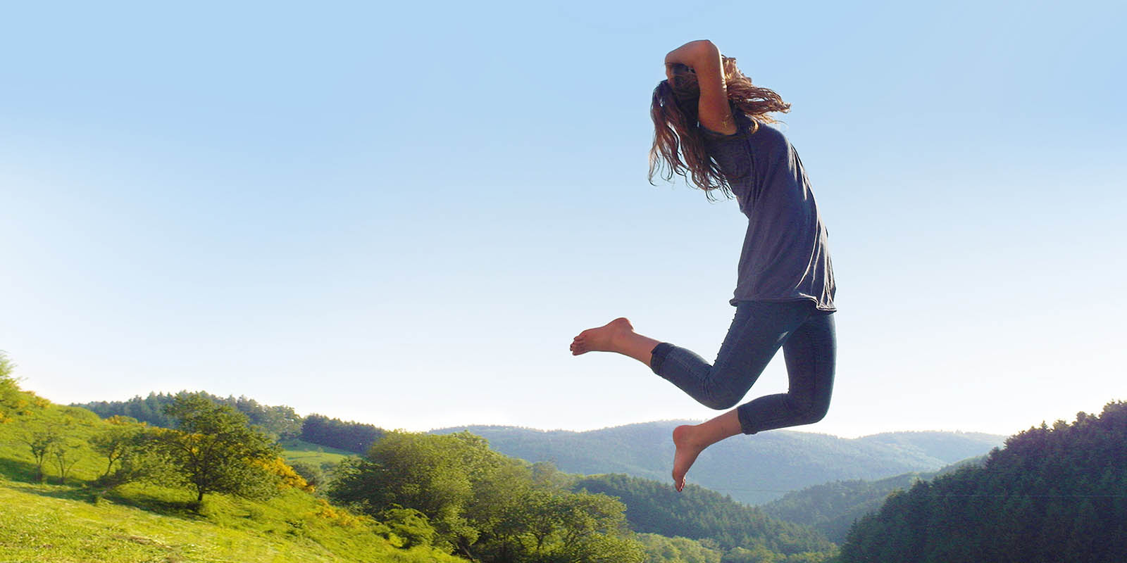 Mädchen springt in die Luft im Schwarzwald